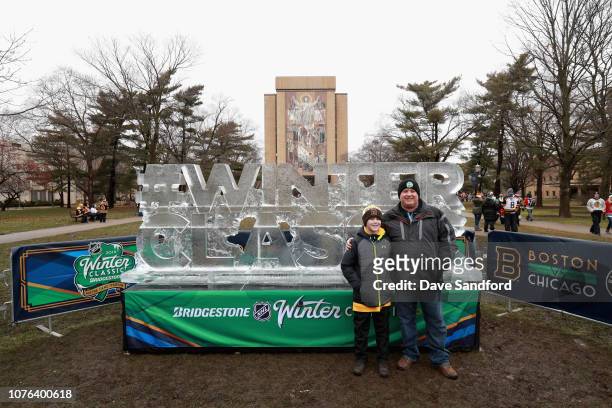 Fans take pictures with the ice sculpture in front of the The Word of Life Mural before the 2019 Bridgestone NHL Winter Classic between the Boston...