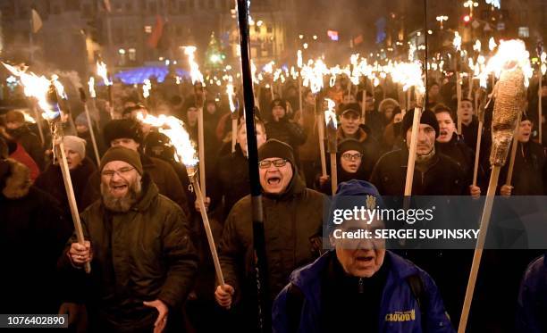 People march with torches in central Kiev on January 1, 2019 to mark the 110th anniversary of the birth of Ukrainian politician Stepan Bandera , one...