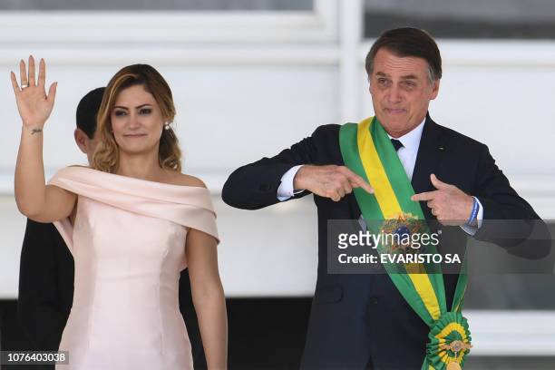 Brazil's new president Jair Bolsonaro gstures next to his wife Michelle Bolsonaro, after receiveing the presidential sash from outgoing Brazilian...