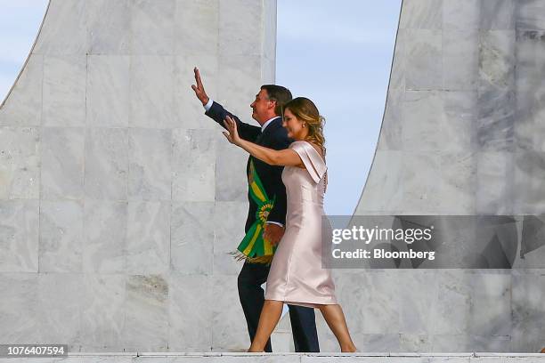 Jair Bolsonaro, Brazil's president, and Michelle Bolsonaro, Brazil's first lady, wave to attendees after speaking during the 38th presidential...