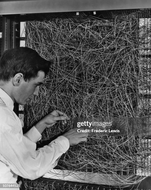 Man adjusting the random wiring network between the light sensors and association unit of scientist Frank Rosenblatt's Perceptron, or MARK 1...