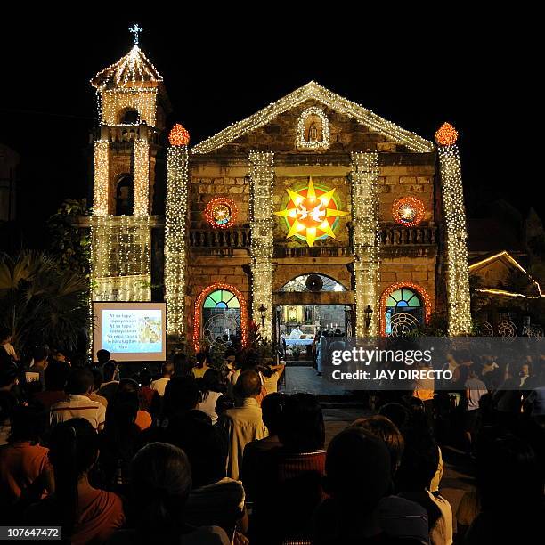 Bright lights outline the facade of the Roman Catholic chapel in Las Pinas district in Manila as Filipinos attend the first of nine dawn masses...