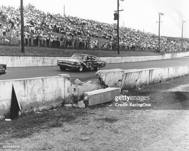 Ervin Pruitt drives his Dodge Charger past the area where Earl Brooks had crashed earlier in the Western North Carolina 500 NASCAR Cup race at...