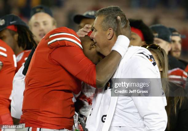 Dwayne Haskins of the Ohio State Buckeyes and Ohio State Buckeyes head coach Urban Meyer embrace after winning the Rose Bowl Game presented by...