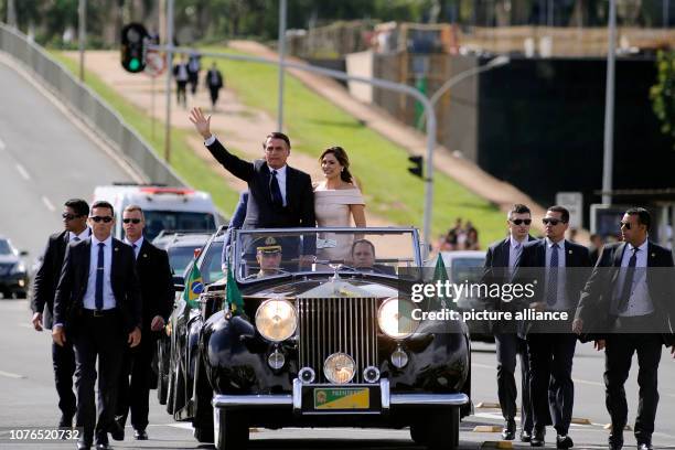 January 2019, Brazil, Brasilia: Brazil's President Jair Bolsonaro waves while he and his wife Michelle drive through the capital Brasilia in an open...