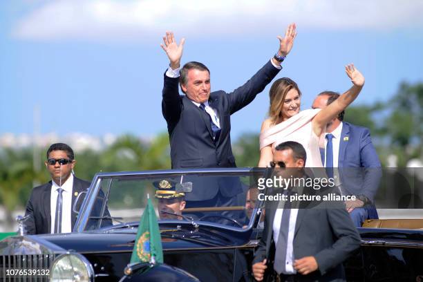 January 2019, Brazil, Brasilia: Brazil's President Jair Bolsonaro waves while he and his wife Michelle drive through the capital Brasilia in an open...