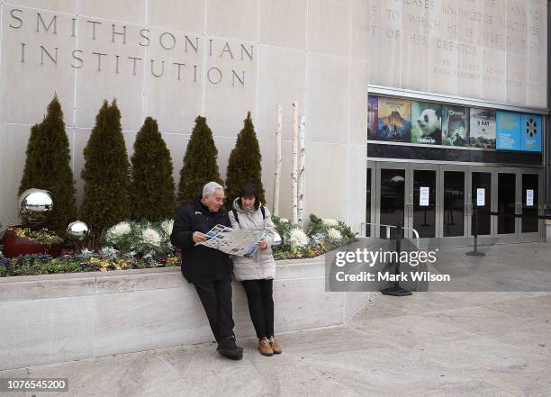 Tourists Enrico and Latisha Jacomini from Rome, Italy, look at a map after discovering the Smithsonian National Museum of American History is closed...