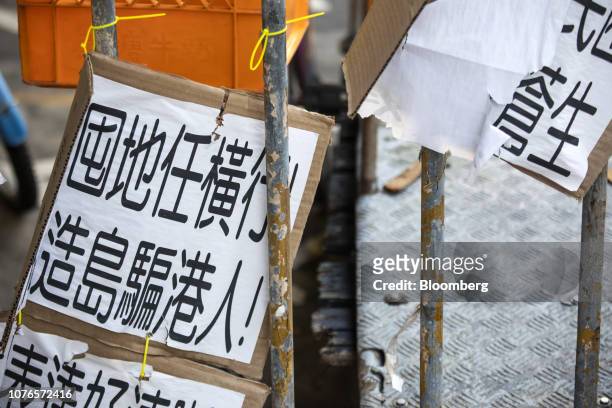 Sign protesting against the building of artificial islands is displayed on a fence on Peng Chau island in Hong Kong, China, on Thursday, Dec. 27,...