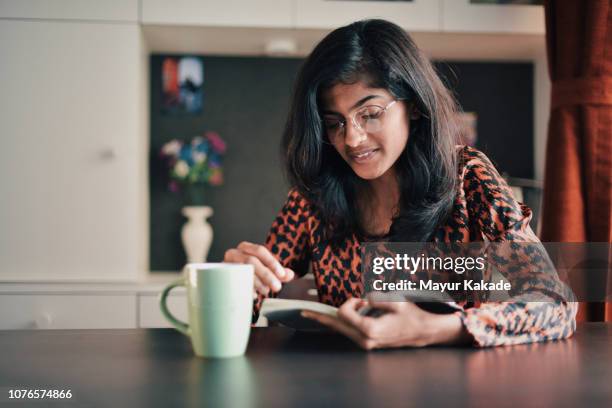 girl reading book with a coffe mug - daily life in india stockfoto's en -beelden