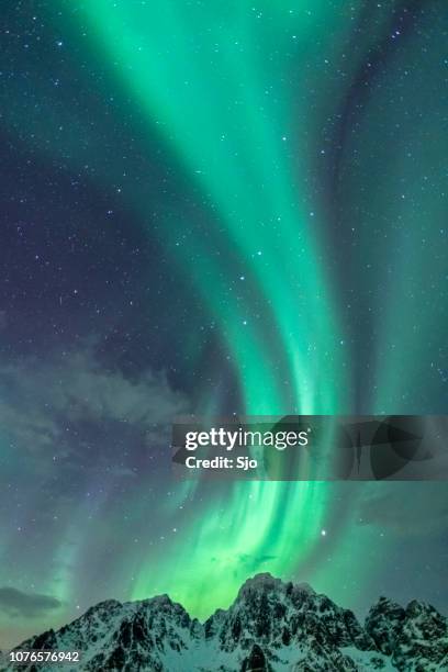 nordlicht-hintergrundbild mit berggipfeln und aurora - aurora borealis stock-fotos und bilder