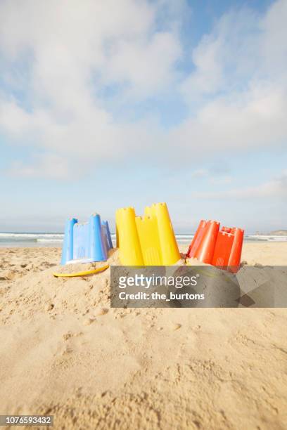 still life of three colorful buckets for building sand castles on the beach against blue sky - sand castle bildbanksfoton och bilder