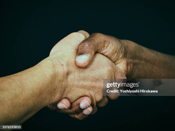 american and a japanese shaking hand - symbiotic relationship bildbanksfoton och bilder
