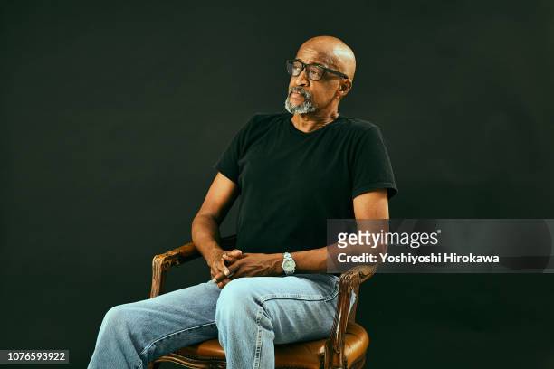 portrait of attractive senior african american. - chairs in studio stockfoto's en -beelden