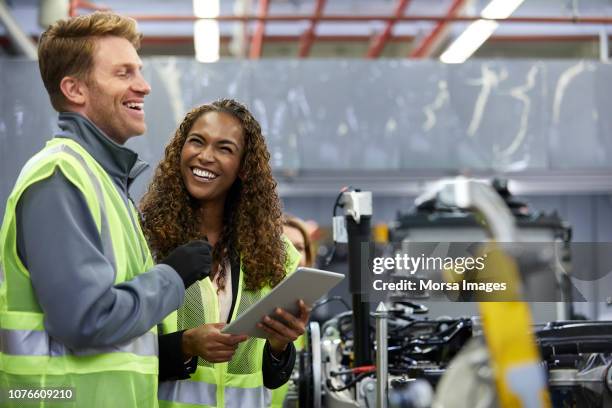 lächelnde ingenieure stehen mit digital-tablette - computer part stock-fotos und bilder