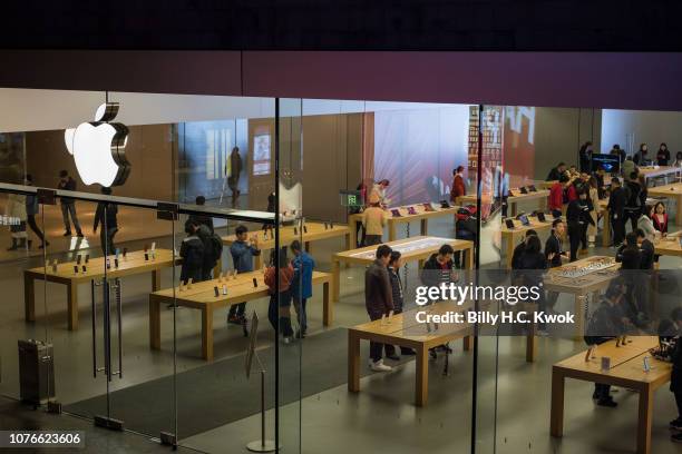 Customers browse inside an Apple Inc. Store in on January 3, 2019 in Shenzhen, China. Apple Inc. Lowered its revenue guidance on Wednesday, blaming...