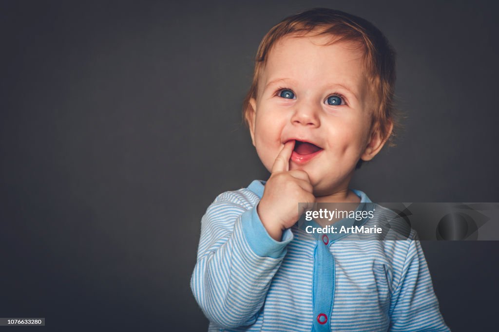 Retrato de estúdio de menino com 9 meses em fundo cinza-azul