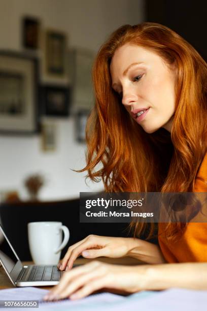 businesswoman working on laptop at home - irish redhead stock pictures, royalty-free photos & images