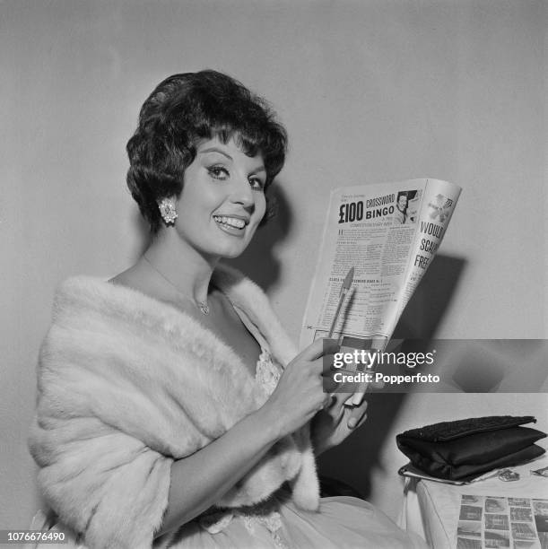 English singer Alma Cogan pictured entering a bingo crossword competition in a magazine in February 1962.