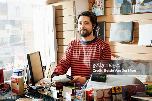 bookseller behind counter in bookshop. - bookshop stock pictures, royalty-free photos & images