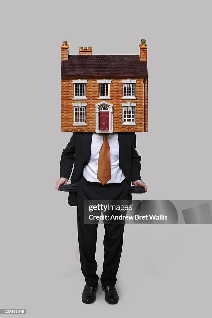 Man with a house on his head, emptying his pockets