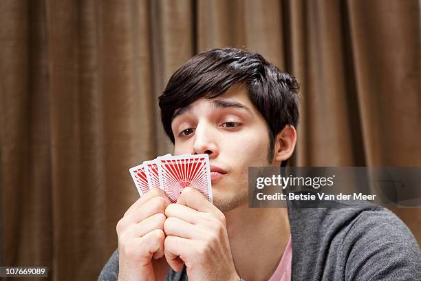 man plaing poker, looking at cards. - thinking of you card stock-fotos und bilder