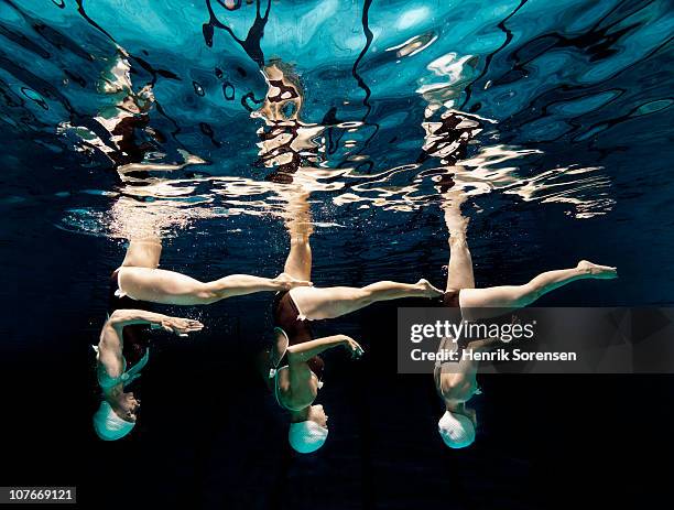 three synchronised swimmers in formation - woman swim team stock pictures, royalty-free photos & images