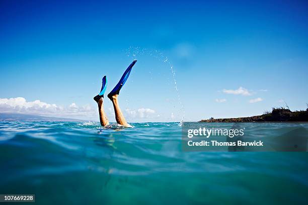 man diving underwater in ocean fins up in the air - maui stock pictures, royalty-free photos & images
