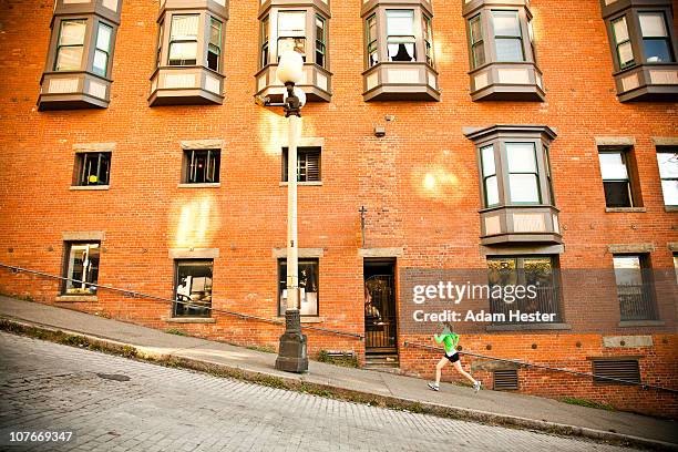 a young women running up a hill in an urban area. - seattle stock-fotos und bilder