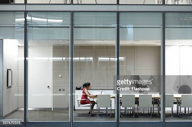 portrait of business woman working late - conference table and chairs stock pictures, royalty-free photos & images