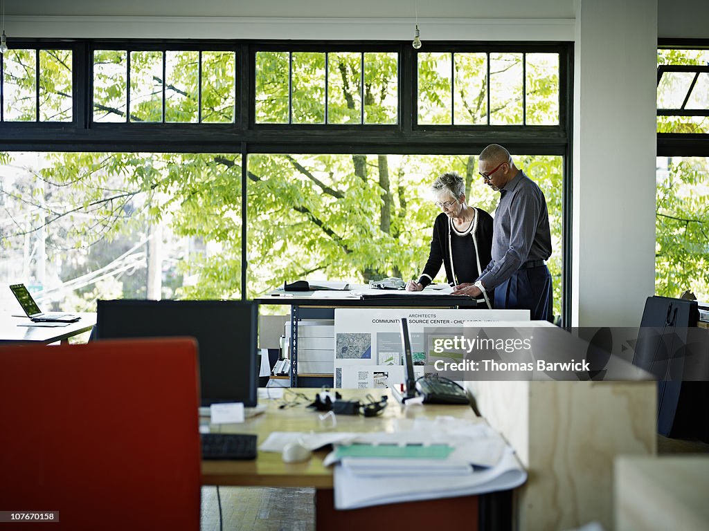 Architects examining plans in office