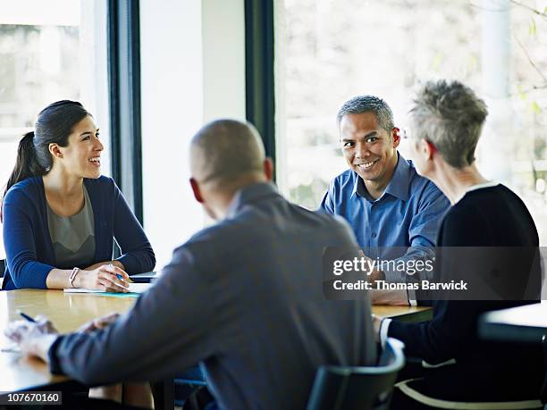 coworkers in planning at conference table - filipino woman smiling stock pictures, royalty-free photos & images