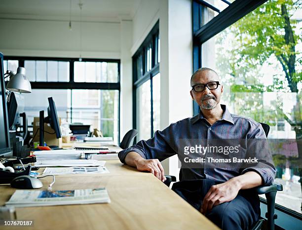 businessman sitting at desk in office - office portrait uomo foto e immagini stock