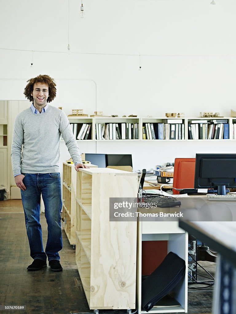 Architect standing in office smiling