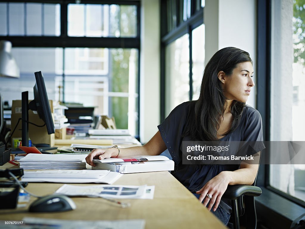 Businesswoman sitting in office looking out