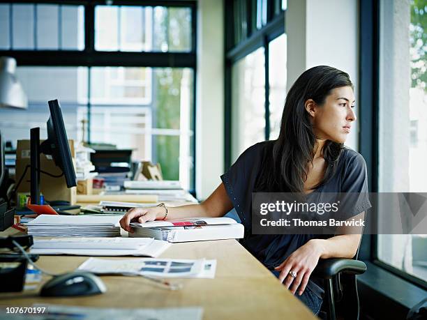 businesswoman sitting in office looking out - desk top view stock pictures, royalty-free photos & images