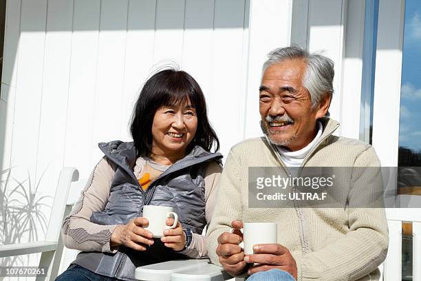 elderly couple drinking coffee - elder couple asian stock-fotos und bilder