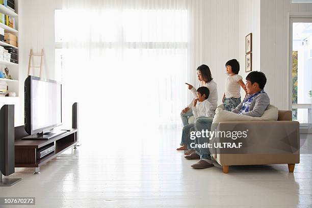 young family watching tv - リビング　家族　日本 ストックフォトと画像