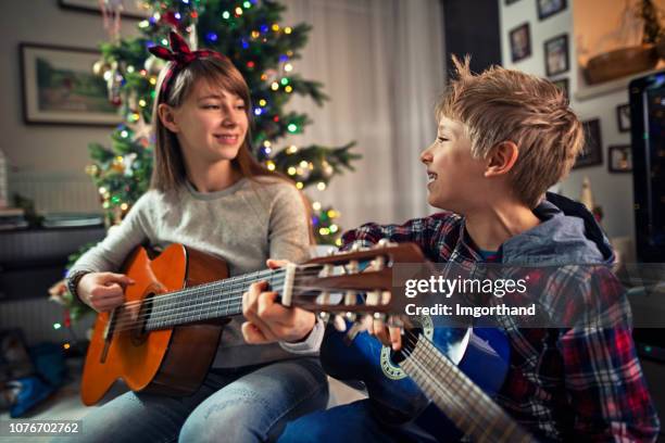 kinder singen weihnachtslieder weihnachtsbaum - weihnachtsmusik stock-fotos und bilder