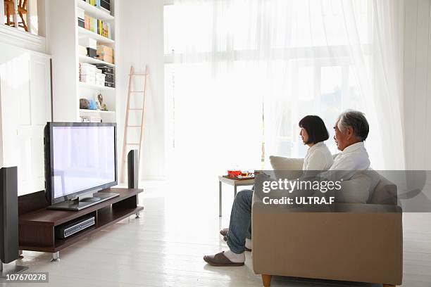 elderly couple who is watching television - tv room side imagens e fotografias de stock