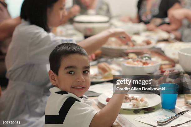 boy at dinner table during thanksgiving dinner - filipino family dinner stock-fotos und bilder