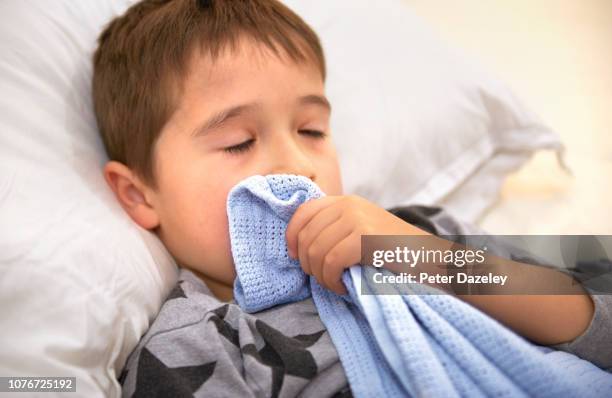 sleeping boy, sucking thumb holding security blanket - thumb sucking stock pictures, royalty-free photos & images