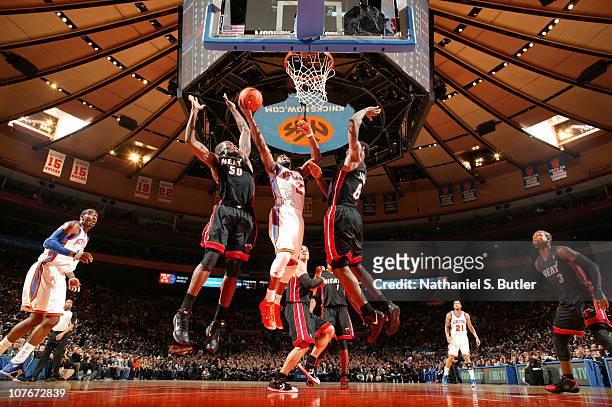 Raymond Felton of the New York Knicks shoots against Joel Anthony and LeBron James of the Miami Heat during a game on December 17, 2010 at Madison...