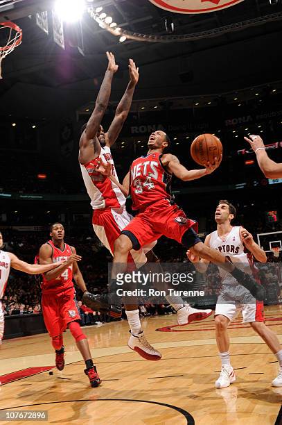 Devin Harris of the New Jersey Nets shoots against Amir Johnson of the Toronto Raptors during a game on December 17, 2010 at the Air Canada Centre in...