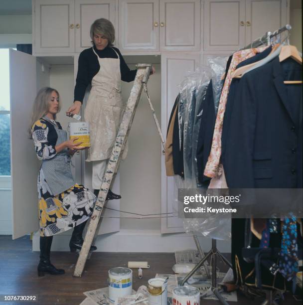 English pop singer Adam Faith decorating his home with his wife Jackie Irving, UK, circa 1970.