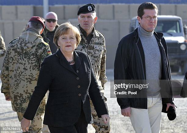 In this photo provided by the German Government Press Office, German Chancellor Angela Merkel and Defense Minister Karl-Theodor zu Guttenberg visit...