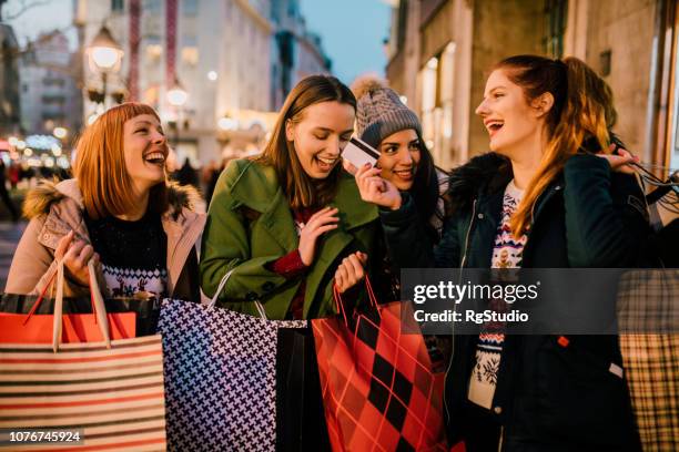 happy girls with credit card - shopaholic stock pictures, royalty-free photos & images