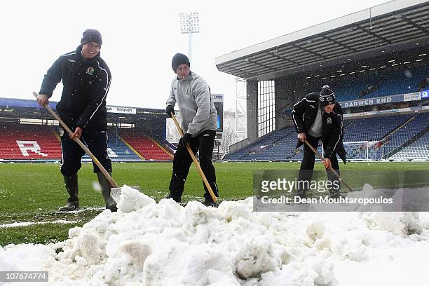 Blackburn staff clear the ground of snow prior to the Barclays Premier League match between Blackburn Rovers and West Ham United at Ewood park on...