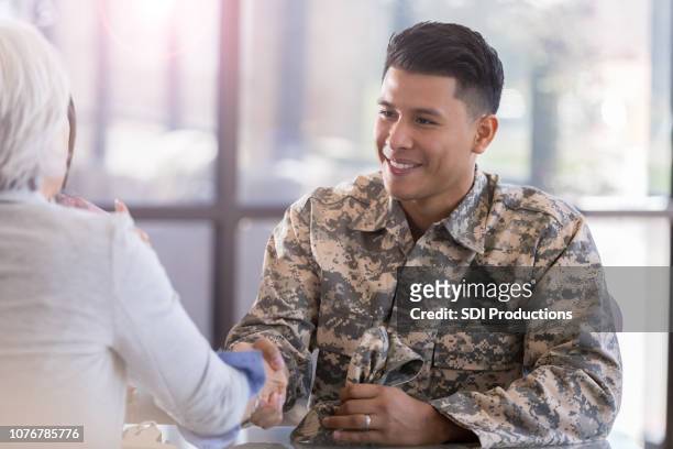 military soldier greets female therapist - veteran stock pictures, royalty-free photos & images