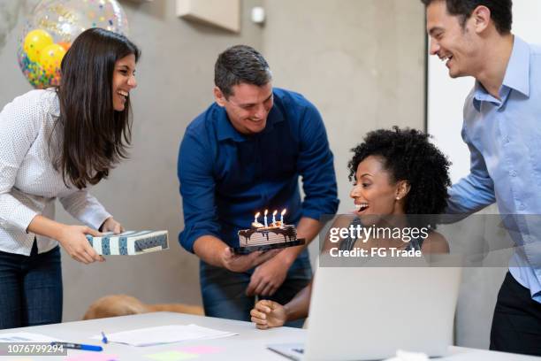 collega's voor het maken van een verrassing in een verjaardag partij op het werk - jubileum werk stockfoto's en -beelden