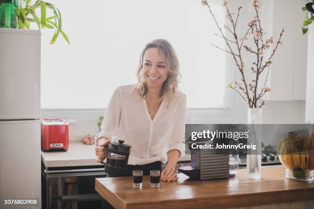 attractive woman pouring espresso in kitchen - coffee plunger stock pictures, royalty-free photos & images